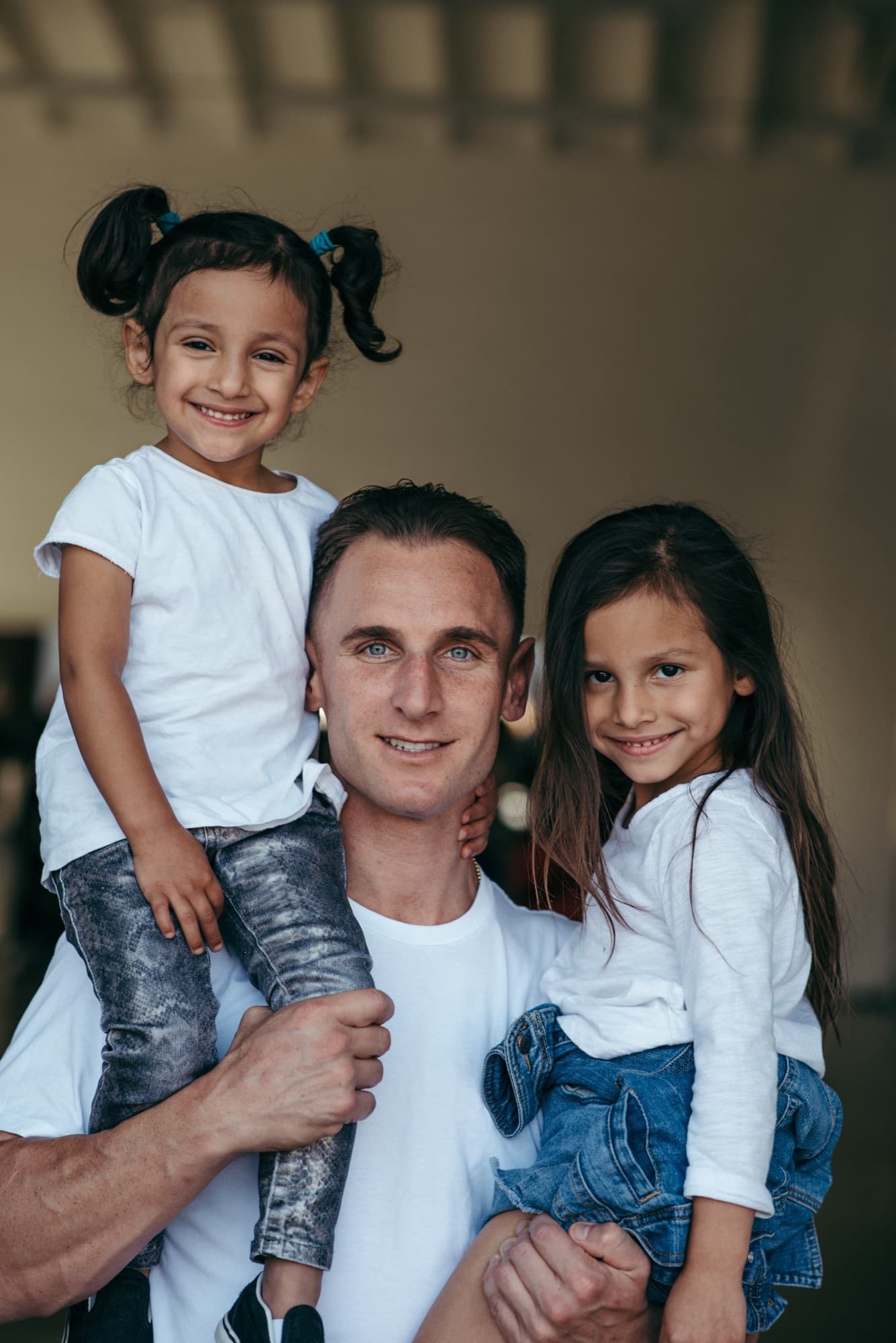 Founder Vince Ricci holding two young girls at a Trina's Kids event