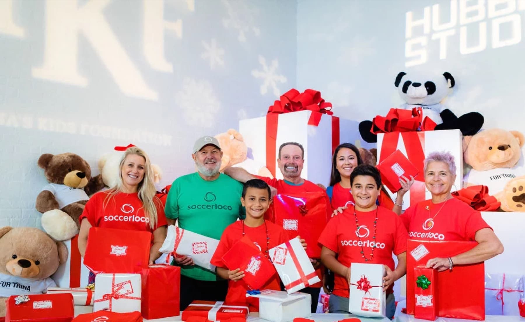 Volunteers and kids with wrapped gifts at the Trina's Kids Holiday Toy Drive