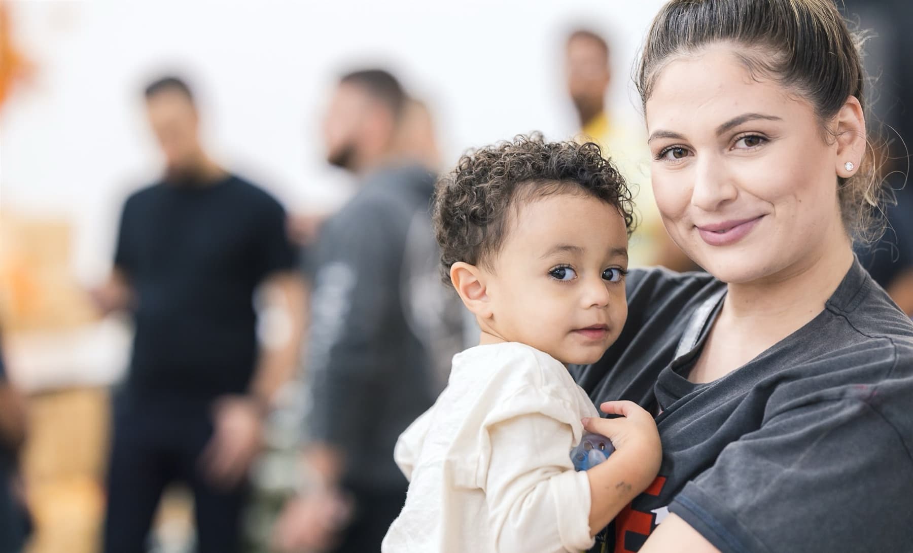 A mother holding her young son at a Trina's Kids event